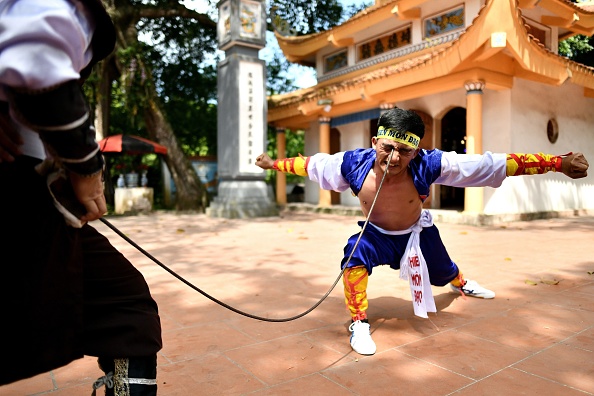 -Le 7 juin 2020 Le Van Thang, 28 ans, étudiant de l'art martial séculaire de Thien Mon Dao, plie une armature de construction contre son orbite à l'intérieur de l'enceinte du temple Bach Linh au village de Du Xa Thuong en Hanoi. Photo de Manan VATSYAYANA / AFP via Getty Images.