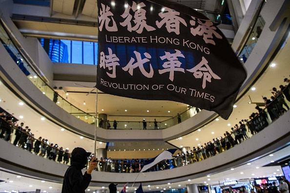 Des manifestants pro-démocratie crient des slogans et agitent des drapeaux lors de leur rassemblent dans un centre commercial à Hong Kong le 16 juin 2020. (Photo : ANTHONY WALLACE/AFP via Getty Images)