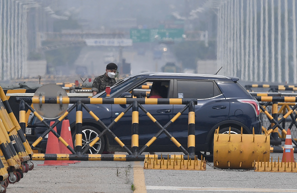 -Un soldat sud-coréen vérifie une voiture à un poste de contrôle sur le pont de Tongil, la route menant au complexe industriel commun de Corée du Nord Kaesong, près de la zone démilitarisée (DMZ) divisant les deux Corées, à Paju le 17 juin 2020. Photo de JUNG YEON-JE / AFP via Getty Images.