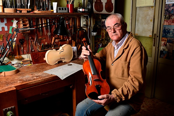 -Le plus ancien luthier actuel de Crémone, le Hongrois Stefano Conia (74 ans), est représenté avec un violon dans son atelier de Crémone le 9 juin 2020. Photo de Miguel MEDINA / AFP via Getty Images.