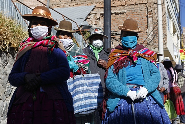 -Des personnes portant des masques faciaux font la queue pour recevoir une prime d'aide gouvernementale à Puno, au Pérou, le 18 juin 2020, au milieu de la pandémie de coronavirus. Photo de CARLOS MAMANI / AFP via Getty Images.