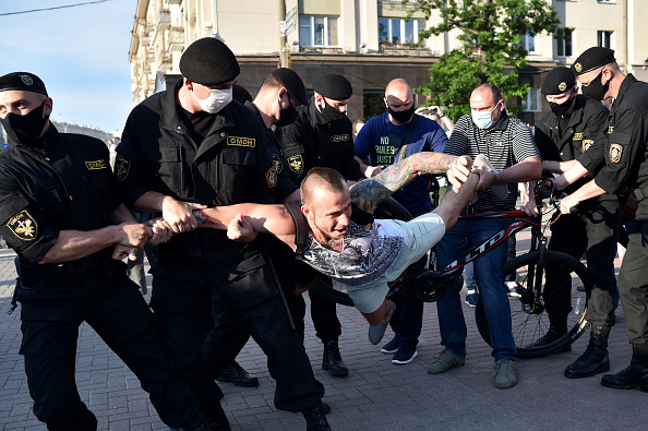 -Des policiers anti-émeutes du Bélarus détiennent un partisan de l'opposition lors d'un rassemblement cherchant à défier le président Alexandre Loukachenko le 19 juin 2020. Photo de Sergei GAPON / AFP via Getty Images.