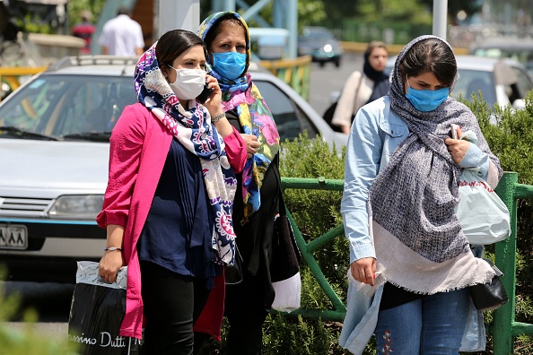 -Des piétons portent des masques de protection en raison du coronavirus COVID-19, marchent dans une rue de la capitale iranienne, Téhéran, le 28 juin 2020. - Photo par ATTA KENARE / AFP via Getty Images.