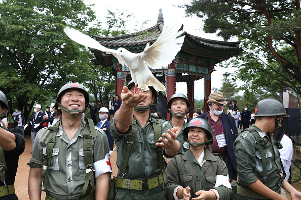 -Des artistes sud-coréens portent des uniformes militaires et libèrent des colombes lors d'une cérémonie pour marquer le 70e anniversaire de la guerre de Corée à Cheorwon, près de la frontière avec la Corée du Nord le 25 juin 2020 en Corée du Sud. Photo par Chung Sung-Jun / Getty Images.