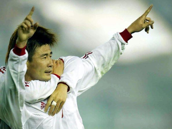 -Le Chinois Hao Haidong célèbre avec un coéquipier invisible après avoir marqué le seul but du match, contre le Koweït. Photo doit se lire STR / AFP via Getty Images.