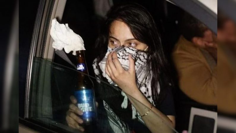 Une femme nommée Urooj Rahman tient un cocktail Molotov sur une image extraite d'une vidéo de surveillance. (Bureau du procureur des États-Unis - District Est de New York) 
