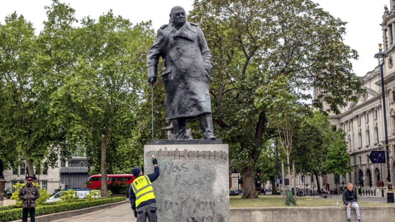 Un ouvrier nettoie la statue de l'ancien Premier ministre Winston Churchill qui a été peinte à la bombe avec des graffitis lors d'une manifestation de Black Lives Matter sur la place du Parlement à Londres, le 8 juin 2020. (Dan Kitwood/Getty Images)