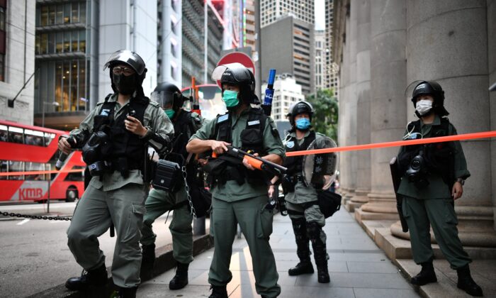 Des policiers anti-émeute montent la garde avant une marche pro-démocratie dans le district central de Hong Kong, le 9 juin 2020, alors que cette ville marquait le premier anniversaire des manifestations contre un projet de loi autorisant les extraditions vers la Chine continentale. (Anthony Wallace/AFP via Getty Images)