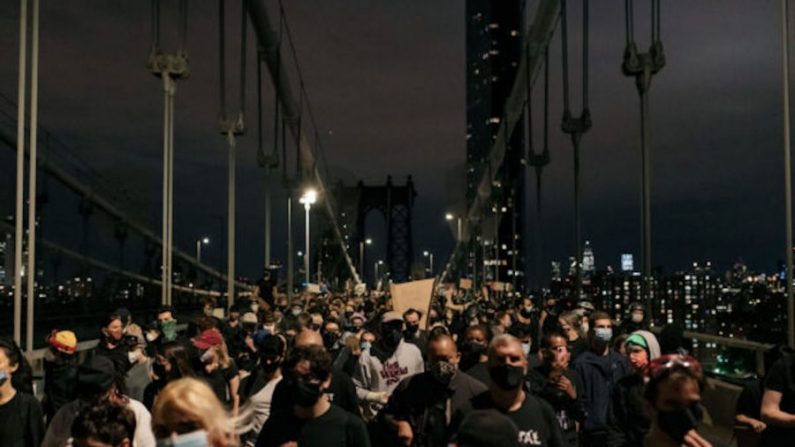 Des manifestants quittent le pont de Manhattan, après avoir été bloqués par la police pendant des heures, lors d'un couvre-feu, à New York City, le 2 juin 2020. (Scott Heins/Getty Images)