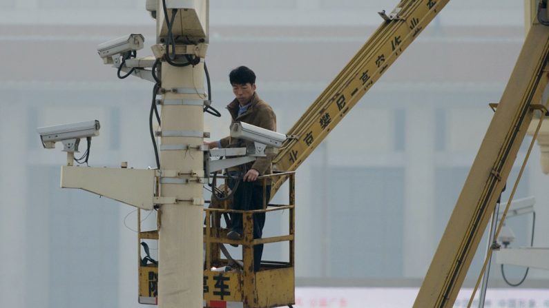 Une photo d'archive montre un homme qui vérifie le fonctionnement des caméras de sécurité sur la place Tiananmen à Pékin, le 31 octobre 2013. (Ed Jones/Getty Images/AFP)