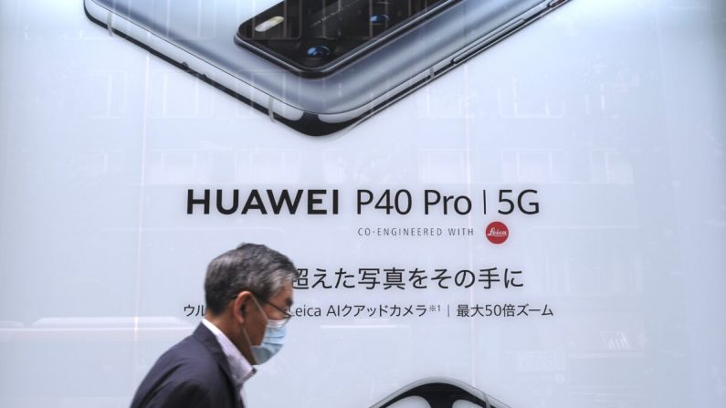 Sur cette photo prise le 27 juin 2020, un homme passe devant une affiche publicitaire pour le dernier smartphone de la société de télécommunications chinoise Huawei à Tokyo. (KAZUHIRO NOGI/AFP via Getty Images)