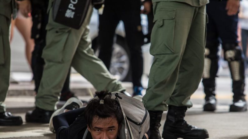 La police anti-émeute détient un homme alors qu'elle procède à l'évacuation des manifestants participant à un rassemblement contre une nouvelle loi sur la sécurité nationale à Hong Kong le 1er juillet 2020, à l'occasion du 23e anniversaire de la rétrocession de la ville à la Chine. (Dale de la Rey/AFP via Getty Images)