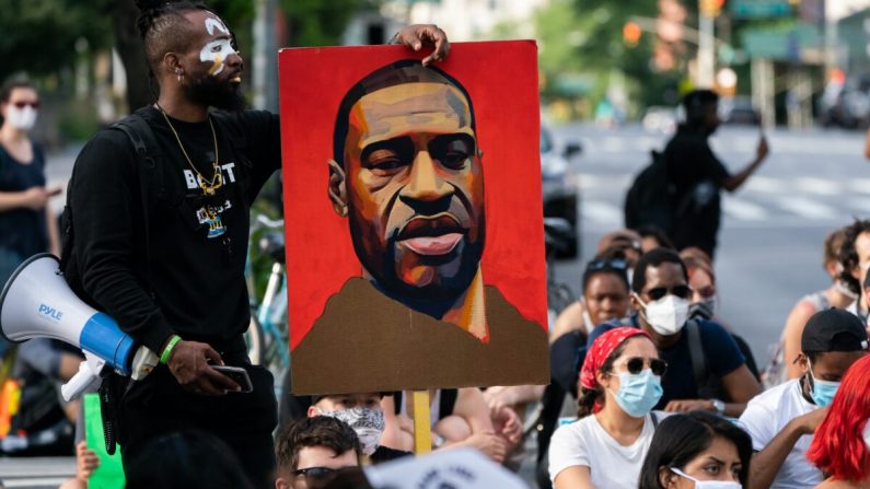 Un homme tient une photo de George Floyd lors d'une manifestation de Black Lives Matter à New York le 18 juin 2020. (Jeenah Moon/Getty Images)