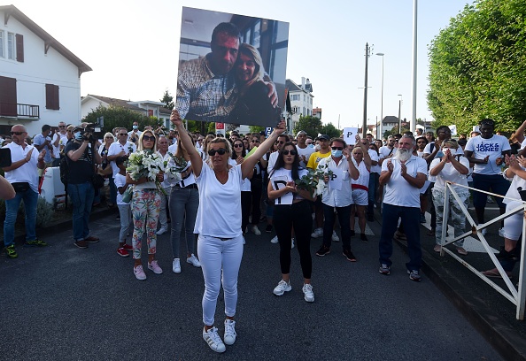Véronique Monguillot, l’épouse du conducteur de bus sauvagement agressé le dimanche 5 juillet, tient à bout de bras une photo de son mari pendant la marche blanche organisée à Bayonne mercredi dernier. Crédit : GAIZKA IROZ/AFP via Getty Images. 