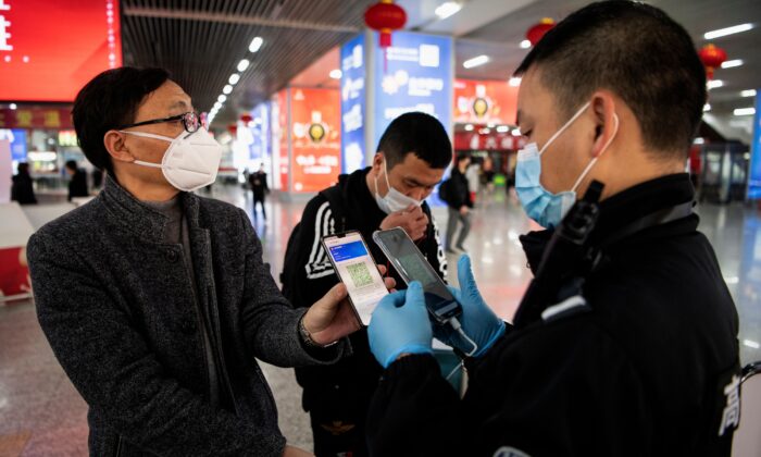 Un passager montre un code QR vert sur son téléphone pour indiquer son état de santé à la sécurité à son arrivée à la gare de Wenzhou, à Wenzhou, Zhejiang, le 28 février 2020. (NOEL CELIS/AFP via Getty Images)