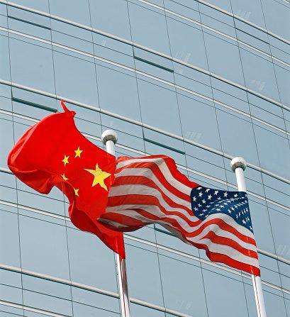 -Illustration- Un drapeau américain et un drapeau chinois s’agitent devant un immeuble commercial à Pékin, le 9 juillet 2007. Photo par TEH ENG KOON / AFP via Getty Images.