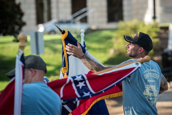 -Les manifestants opposés au changement du drapeau de l'État du Mississippi déroulent leurs drapeaux à l'extérieur du bâtiment du Capitole de l'État du Mississippi lors du vote historique de l'Assemblée législative pour changer le drapeau du Mississippi à Jackson, Mississippi le 28 juin 2020. Photo de RORY DOYLE / AFP via Getty Images.