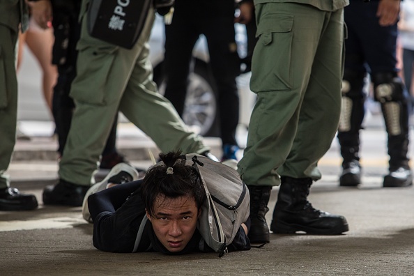 -La police anti-émeute arrête un homme alors qu'ils dégageaient des manifestants participant à un rassemblement contre une nouvelle loi sur la sécurité nationale à Hong Kong le 1er juillet 2020. Photo de DALE DE LA REY / AFP via Getty Images.