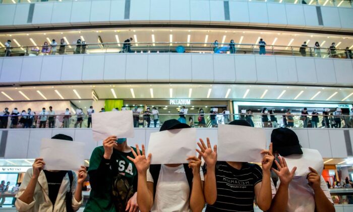 Des manifestants brandissent des papiers vierges lors d'une manifestation dans un centre commercial de Hong Kong le 6 juillet 2020. (Isaac Lawrence/AFP via Getty Images)