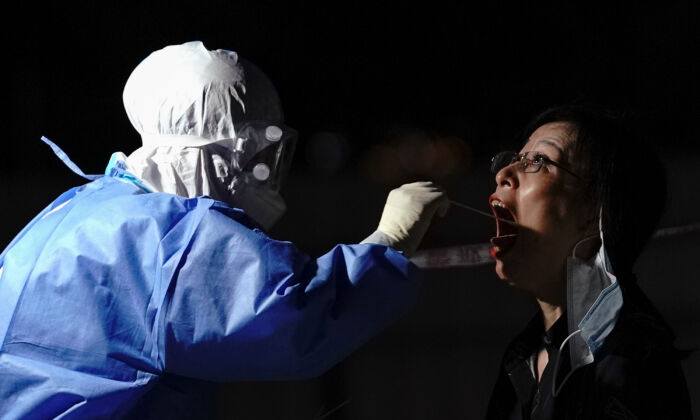 Un travailleur médical prélève un échantillon par écouvillonnage dans un centre de dépistage à Pékin le 6 juillet 2020. (Lintao Zhang/Getty Images)