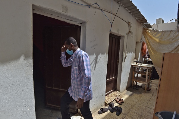 -L'électricien soudanais Hatem, vêtu d'un masque et pauvre de 45 ans, endetté et dont le permis de séjour a expiré, vit caché pour éviter d'être arrêté dans la capitale saoudienne Riyad le 6 juin 2020. Photo de FAYEZ NURELDINE / AFP via Getty Images.