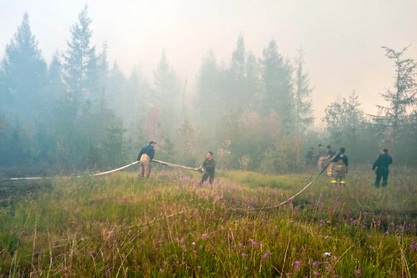 -Cette capture extraite d'une vidéo non datée publiée par le ministère russe des urgences montre des pompiers qui luttent pour éteindre les incendies de forêt près du village de Batagay, en République de Sakha en Yakoutie. Photo de - / MINISTERE D'URGENCE RUSSE / AFP via Getty Images.