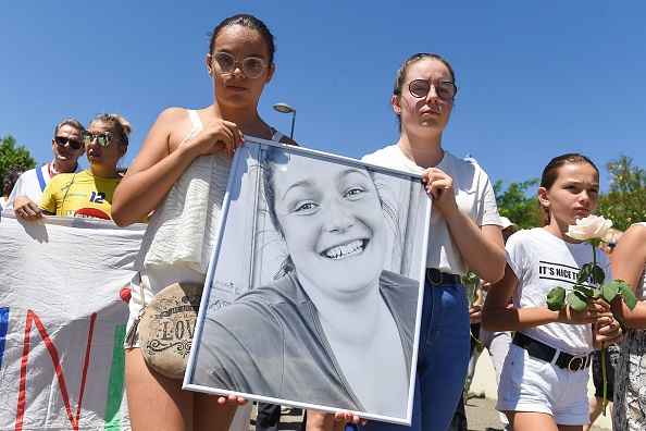 Deux jeunes filles tiennent un portrait de Mélanie Lemée lors d'une marche blanche en mémoire à la gendarme. (NICOLAS TUCAT/AFP via Getty Images)