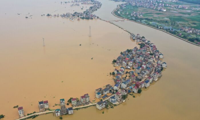 Les autorités libèrent les eaux du lac Poyang. Cette vue aérienne montre les rues submergées et les bâtiments inondés après la rupture d'un barrage, à la suite des inondations à Jiujiang, en Chine, le 13 juillet 2020. (STR/AFP via Getty Images)