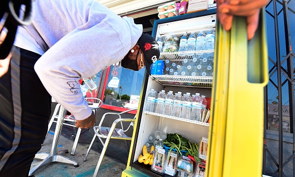-Solo Morris sort du café Little Amsterdam à Los Angeles, Californie le 16 juillet 2020 pour réapprovisionner le réfrigérateur. Photo de Frédéric J. BROWN / AFP via Getty Images.