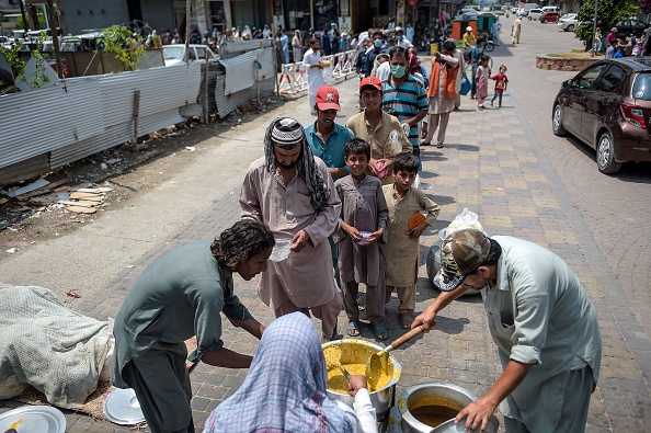 -Les gens font la queue pour obtenir de la nourriture gratuite dans un point de distribution à Rawalpindi le 25 juillet 2020. - Les tests sont encore limités, les taux réels seraient beaucoup plus élevés. Photo par FAROOQ NAEEM / AFP via Getty Images.