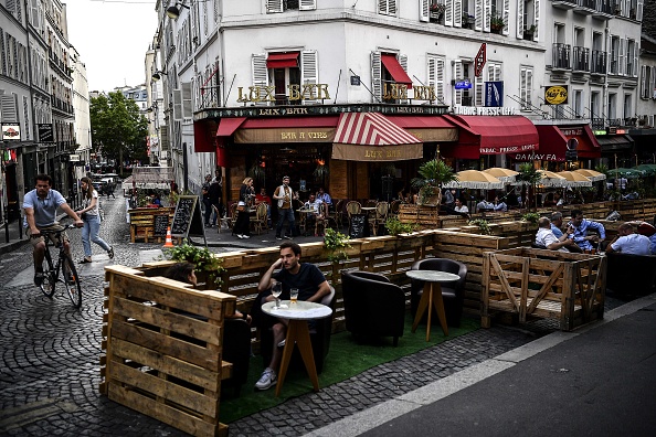  -Les gens prennent un verre sur la terrasse prolongée d'un café en palettes en bois à Paris le 23 juillet 2020, dans le respect de la distanciation sociale due à la pandémie de coronavirus. Photo par CHRISTOPHE ARCHAMBAULT / AFP via Getty Images.