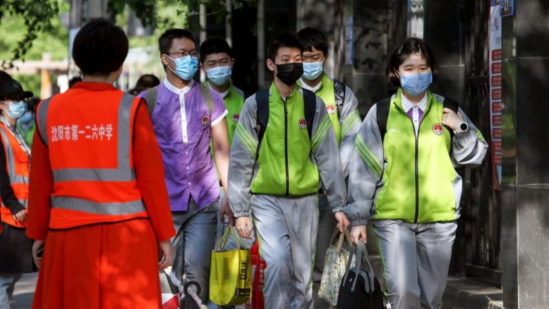 Des étudiants qui portent des masques font la queue pour entrer dans un collège à Shenyang, dans la province du Liaoning au nord-est de la Chine, le 29 mai 2020. (STR/AFP via Getty Images)