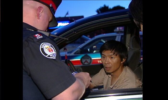 La police de Toronto interroge Lu Ping sur sa livraison du tabloïd anti-Falun Gong de Crescent Chau le 30 juin 2007 à l'épicerie Asian Farm dans le nord-est de Toronto. (NTDTV)