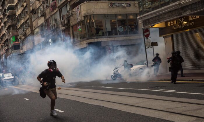 La police anti-émeute déploie des gaz lacrymogènes alors qu'elle évacue les manifestants d'une route lors d'un rassemblement contre une nouvelle loi de sécurité nationale à Hong Kong le 1er juillet 2020, à l'occasion du 23e anniversaire de la rétrocession de la ville de la Grande-Bretagne à la Chine. (Dale de la Rey/AFP via Getty Images)