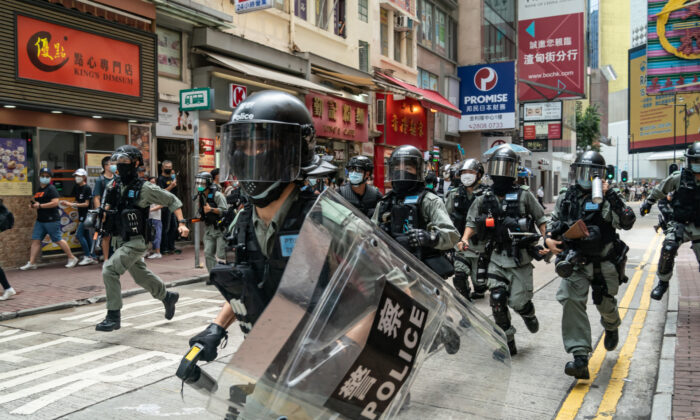 La police anti-émeute court dans une rue en direction des piétons lors d'une opération de contrôle de la foule pendant une manifestation à Hong Kong, le 1er juillet 2020. (Anthony Kwan/Getty Images)