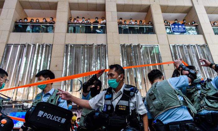 La police entre dans un centre commercial pour disperser les personnes qui assistent à un rassemblement à l'heure du déjeuner à Hong Kong le 30 juin 2020, alors que la Chine a adopté une loi de sécurité nationale de grande envergure pour la ville. (Anthony Wallace/AFP via Getty Images)