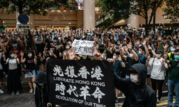 La police anti-émeute détient un homme alors qu'elle hisse un drapeau d'avertissement au cours d'une manifestation contre la nouvelle loi sur la sécurité nationale à Hong Kong, le 1er juillet 2020. (Anthony Kwan/Getty Images)