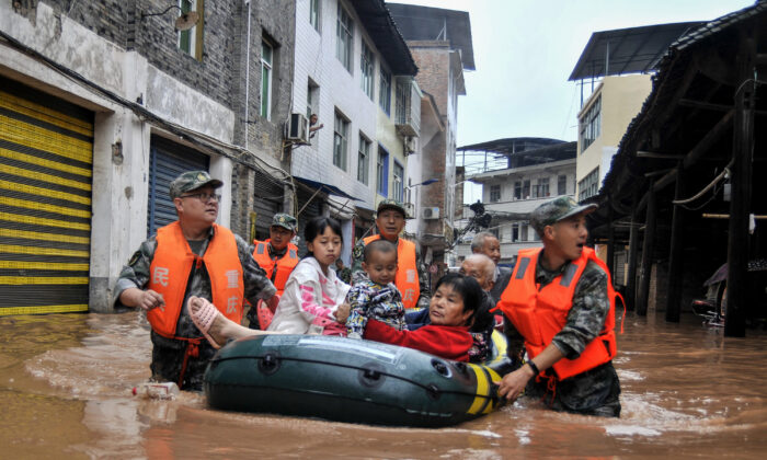 Cette photo prise le 28 juin 2020 montre les sauveteurs évacuant les habitants d'une zone inondée après de fortes pluies dans le sud-ouest de la Chine, à Chongqing. (STR/AFP via Getty Images)