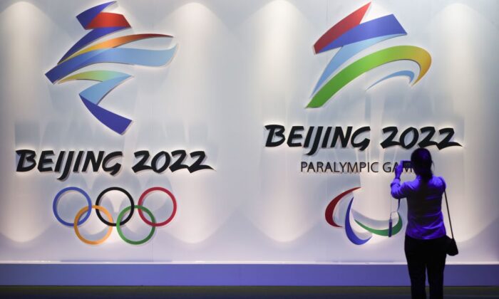 Un visiteur prend des photos des logos des Jeux olympiques et paralympiques d'hiver de Pékin 2022 pendant l'Expo olympique de Pékin le 8 août 2018. (Wang Zhao/AFP via Getty Images)