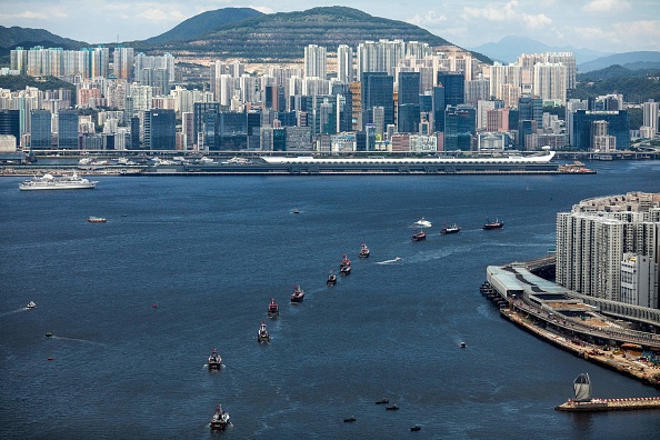 -Des bateaux de pêche naviguent dans le port de Victoria à Hong Kong le 1er juillet 2019, pour marquer le 22e anniversaire du transfert de la Grande-Bretagne à la Chine. Photo Dale DE LA REY / AFP via Getty Images