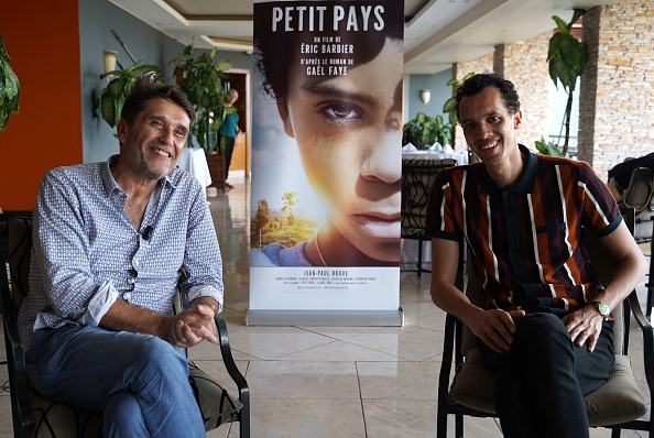 -L'écrivain franco-rwandais Gaël Faye l'auteur du roman "Petit Pays" s'assoit avec le réalisateur français Éric Barbier lors d'un entretien à Kigali le 7 mars 2020. Photo par Simon WOHLFAHRT / AFP via Getty Images.
