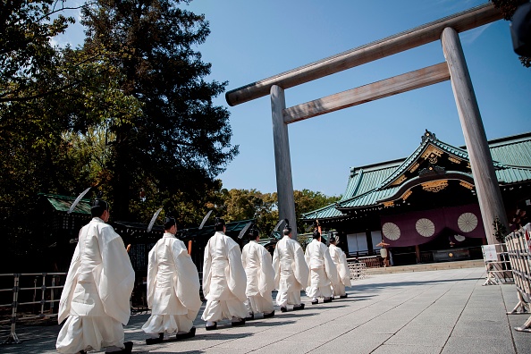 -Des prêtres marchent vers le sanctuaire extérieur pour effectuer un rituel shintoïste lors du festival annuel du printemps au sanctuaire Yasukuni à Tokyo le 22 avril 2020. Photo de Behrouz MEHRI / AFP via Getty Images.
