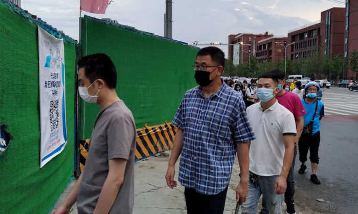 Les gens portent des masques de protection lorsqu'ils font la queue pour subir des tests de dépistage du coronavirus par écouvillonnage dans un centre temporaire à Pékin, en Chine, le 6 juillet 2020. (Lintao Zhang/Getty Images)
