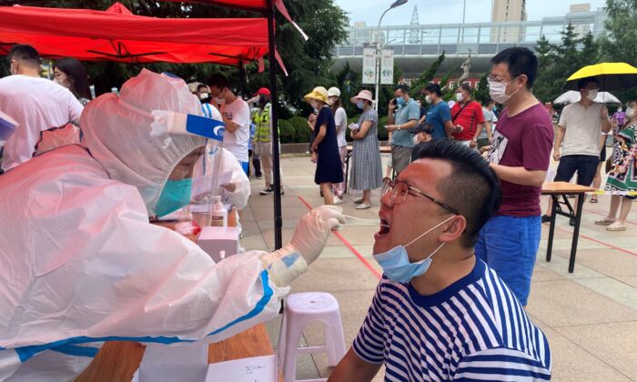 Un professionnel de la santé effectue un test pour le Covid-19 à Dalian, dans la province du Liaoning, au nord-est de la Chine, le 26 juillet 2020. (STR/AFP via Getty Images)