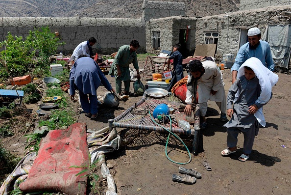 -Des villageois afghans nettoient leur maison touchée après des inondations soudaines déclenchées par de fortes pluies et des tempêtes de grêle dans la province de Nangarhar, le 1er août 2020. Photo de NOORULLAH SHIRZADA / AFP via Getty Images.