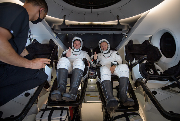 -Les astronautes de la NASA Robert Behnken et Douglas Hurley sont vus à l'intérieur de la capsule spatiale SpaceX Crew Dragon qui a atterri dans le golfe du Mexique le 2 août 2020 au large de Pensacola, en Floride. Photo Bill Ingalls/NASA via Getty Images.