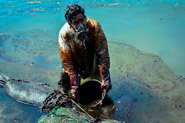 - Un homme récupère du pétrole provenant du navire MV Wakashio, qui s'est échoué près du parc marin de Blue Bay au large des côtes du sud-est de l'île Maurice le 8 août 2020. Photo par JEAN AURELIO PRUDENCE / L'Express Maurice / AFP via Getty Images.