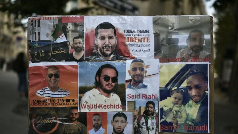 Des portraits de détenus algériens exposés devant l'ambassade d'Algérie à Paris, le 12 août 2020, lors d'une manifestation de soutien au journaliste algérien emprisonné Khaled Drareni. (Stephane De Sakutin/ AFP) 