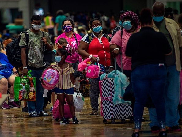 -Les gens se préparent à monter à bord d'un bus pour une évacuation avant l'arrivée de l'ouragan Laura à Lake Charles, en Louisiane, le 25 août 2020.  Photo par Andrew CABALLERO-REYNOLDS / AFP via Getty Images.
