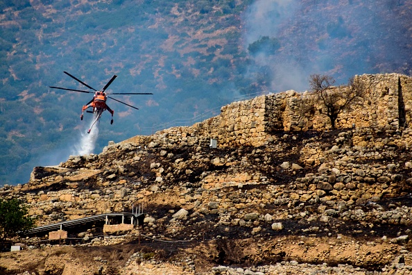 -Un hélicoptère de lutte contre les incendies laisse tomber de l'eau pour éteindre les flammes près du site archéologique de Mycènes, le 30 août 2020. - Photo par - / Eurokinissi / AFP via Getty Images.